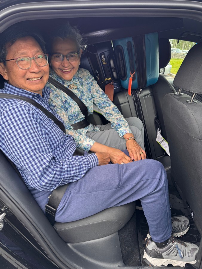 picture of my dad and mom in the back seat of a car squeezed in with the luggage—but all smiles!